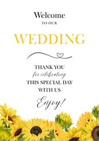 A wedding welcome sign or card with yellow sunflower illustrations along the bottom. The text reads 'Welcome to our WEDDING' in black and yellow lettering, followed by 'Thank you for celebrating this special day with us' and 'Enjoy!' on a white background.