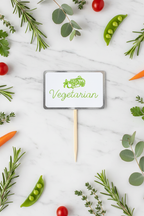 Vegetarian food display sign flat lay with fresh herbs and vegetables on marble